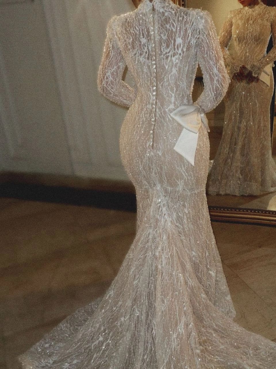 Beaded floor-length wedding gown with a sweeping train, shown from behind