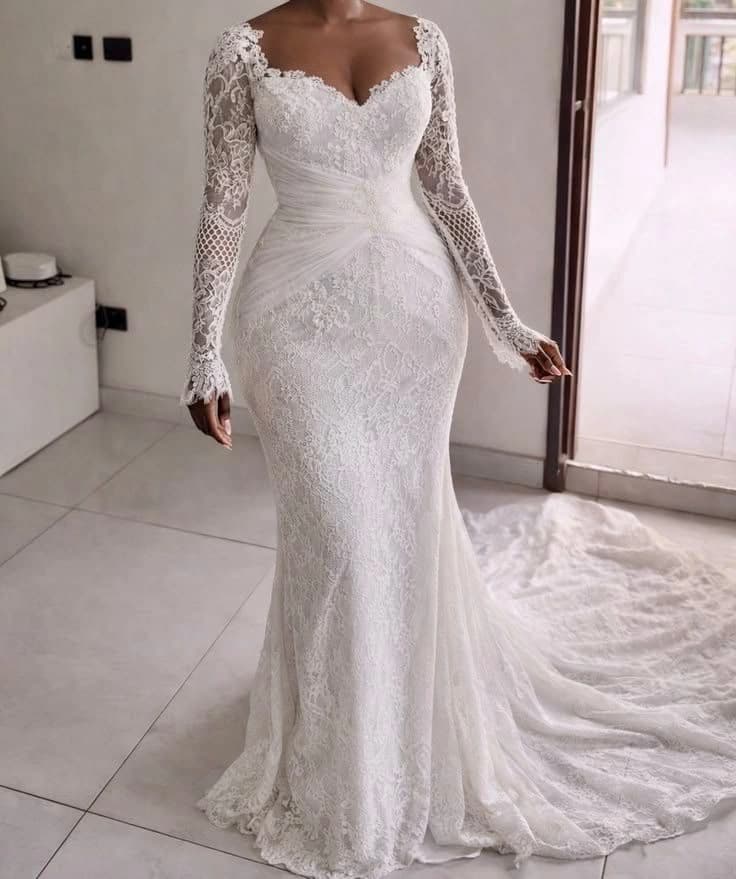 Bride wearing a fitted long-sleeve white lace wedding gown